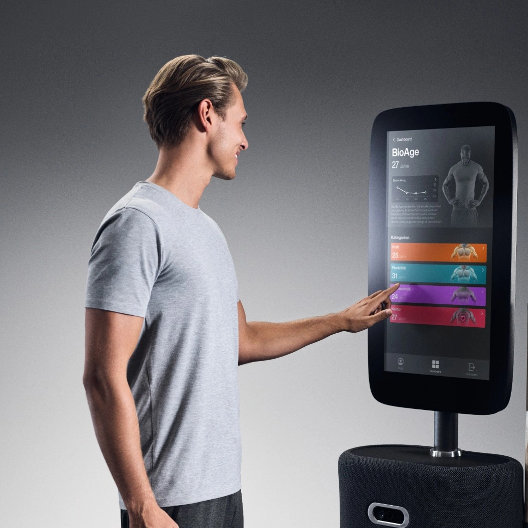 Mann bedient den Touchscreen des EGYM Fitness Hub zur digitalen Körperanalyse